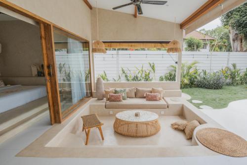 Gili Boho Villas - Aesthetic Private Pool Villas في غيلي تراوانغان: غرفة معيشة مع أريكة وطاولة