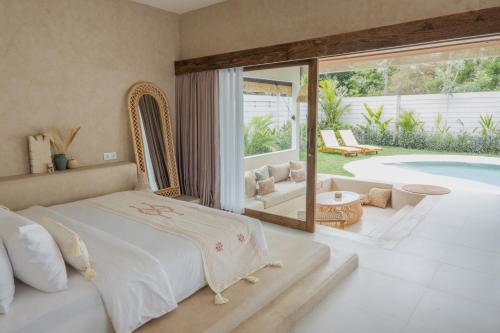 a bedroom with a bed and a swimming pool at Gili Boho Villas - Aesthetic Private Pool Villas in Gili Trawangan