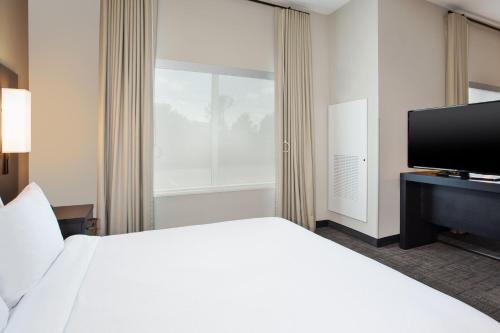 a hotel room with a bed and a flat screen tv at Residence Inn By Marriott Wichita Falls in Wichita Falls