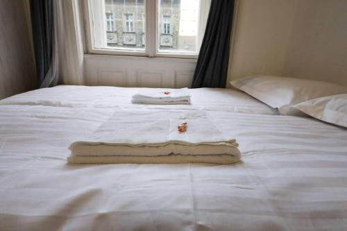 Una cama blanca con toallas y una ventana. en Pest-port apartment room-5 Private apartment, en Budapest