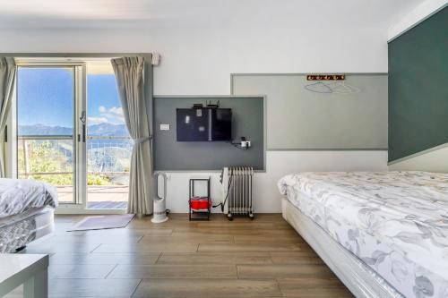 a bedroom with a bed and a tv on the wall at Water Swing B&B in Renai