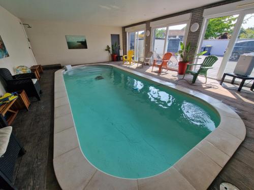ein großer Pool in der Mitte eines Wohnzimmers in der Unterkunft Magnifique villa Boubou 300m2 avec piscine in Troarn