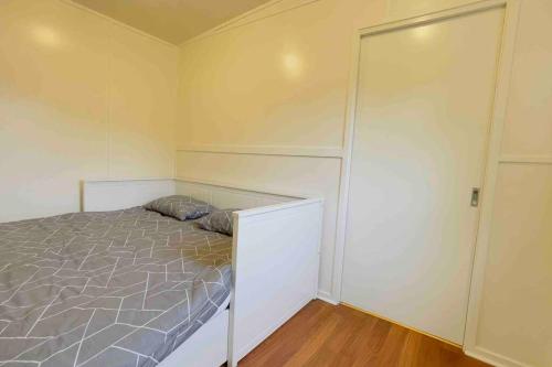 a bedroom with a bed and a closet at Tiny house at Gilderoy Valley Views in Yarra Junction