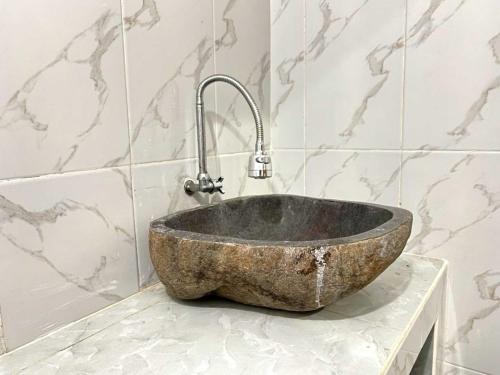 a stone sink on a counter in a bathroom at Serene Wilderness Villa Batur Natural Hot Spring in Kintamani