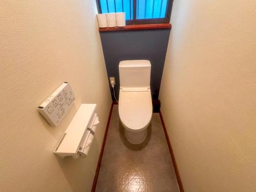 a small bathroom with a toilet in a stall at FUJI NINJA HOUSE in Fujiyoshida
