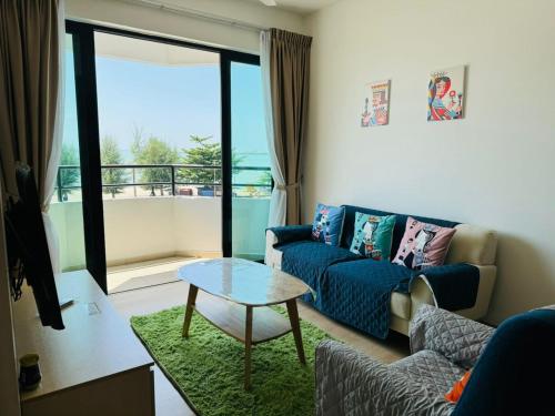 a living room with a couch and a table at Mutiara Melaka Beach Resort by Minso in Tangga Batu