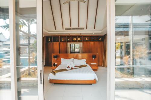 a bedroom with a bed and some glass doors at Oasis Villa Pattaya in Ban Bung