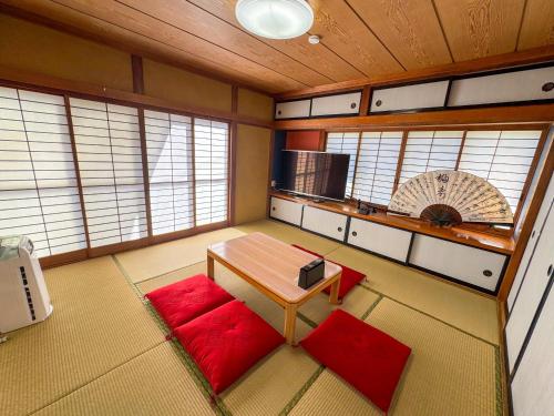 a small room with a table and red cushions at FUJI NINJA HOUSE in Fujiyoshida