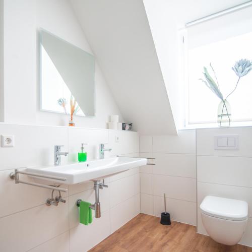 a white bathroom with a sink and a toilet at StayS Apartments in Nuremberg