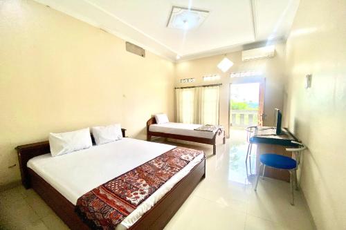 een slaapkamer met een bed, een bureau en een televisie bij OYO 93600 Barong Ijo Homestay Syariah in Yogyakarta