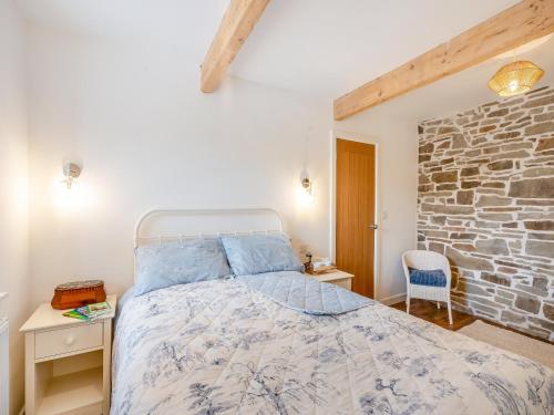 Winter Cottage : غرفة نوم بسرير وجدار حجري