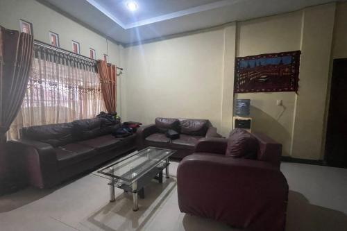 a living room with two couches and a coffee table at OYO 93609 Syukur 07 Syariah in Medan