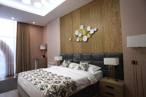 a bedroom with a large bed and flowers on the wall at IsraHotel Dushanbe in Dushanbe