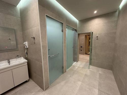 a bathroom with a glass door and a sink at IsraHotel Dushanbe in Dushanbe