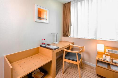 a small room with a desk and a chair at China Mayors Plaza - Free shuttle between hotel and Exhibition Center during Canton Fair in Guangzhou
