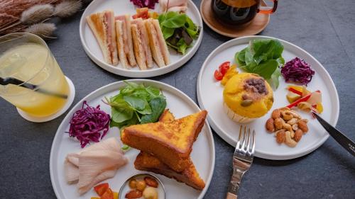 una mesa con platos de comida y un vaso de zumo en BnA WALL en Tokio