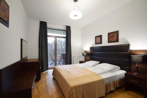 een slaapkamer met een groot bed en een raam bij Diune Resort & Apartamenty in Kołobrzeg