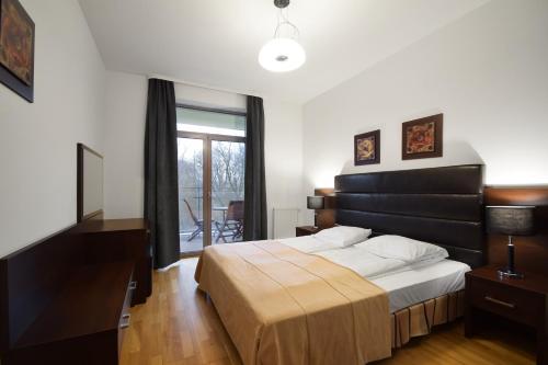 ein Schlafzimmer mit großem Bett und Fenster in der Unterkunft Diune Resort & Apartamenty in Kołobrzeg