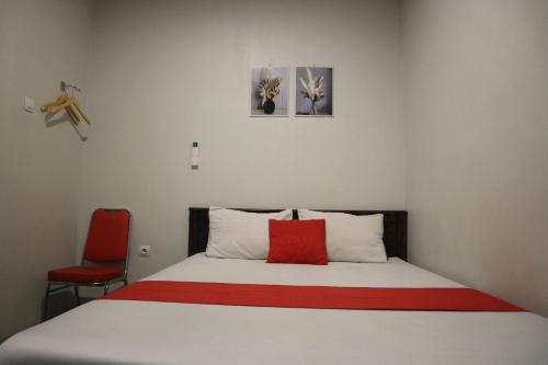 ein Schlafzimmer mit einem Bett mit einem roten Kissen in der Unterkunft K1 UPN in Surabaya
