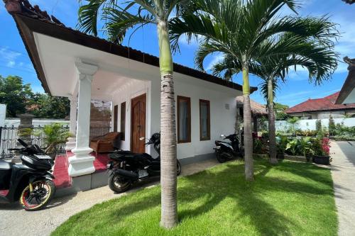 two motorcycles parked in front of a house with palm trees at Belvilla Pleasant Seaside Lovina Beach in Lovina