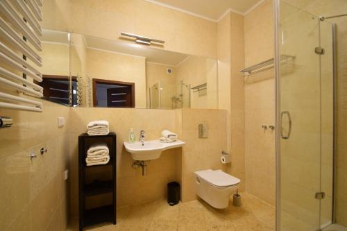 a bathroom with a sink and a toilet and a shower at Diune Resort & Apartamenty in Kołobrzeg