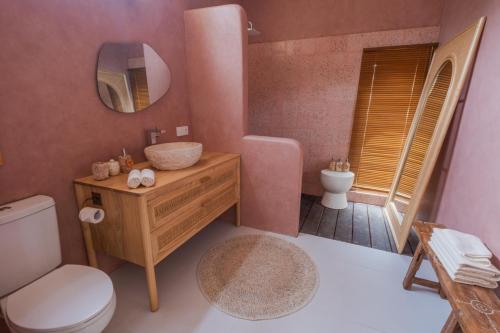 a bathroom with a sink and a toilet and a mirror at Gili Boho Villas - Aesthetic Private Pool Villas in Gili Trawangan
