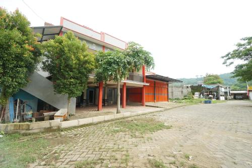 a building with trees in front of a street at SPOT ON 93620 Anisa Homestay Syariah in Tulungagung