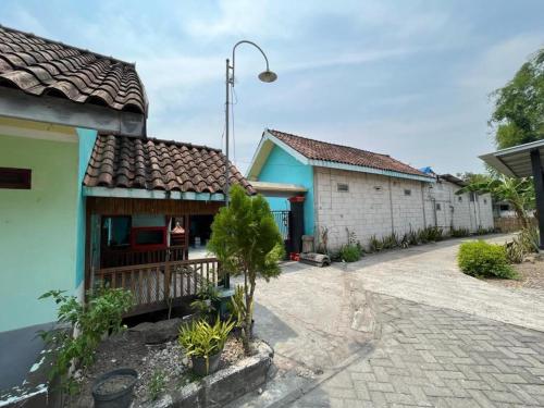 ein Haus mit einem blauen Gebäude und einer Straße in der Unterkunft SPOT ON 93621 Kost Bu Tutik Syariah in Lawang