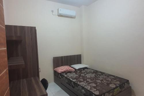 una piccola camera con un piccolo letto in una stanza di OYO 93623 Assalam Homestay Syariah a Surabaya