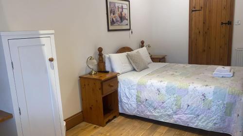 a small bedroom with a bed and a night stand at Church Farm Accommodation in Bickenhill