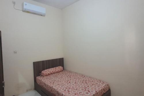 uma pequena cama num canto de um quarto em OYO 93625 Uno Homestay Syariah em Surabaya