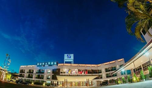 un edificio con un cartello sopra di esso di notte di Buritel Hotel a Buriram