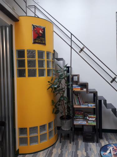 een gele muur naast een trap met een plant bij lapetitemaisondeparis in Parijs