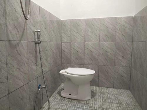 La salle de bains est pourvue d'une douche et de toilettes. dans l'établissement OYO 93630 Wongso Residence Syariah, à Pangkal Pinang