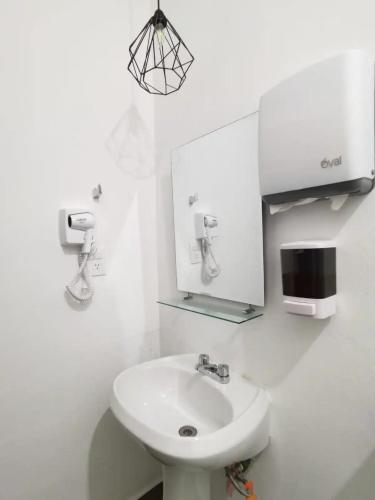 a white bathroom with a sink and a mirror at La casa del faro Azul Marino in Mazatlán