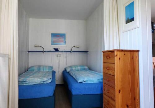 - une chambre avec 2 lits et une commode dans l'établissement Möve Aba Bungalow 66, à Rerik