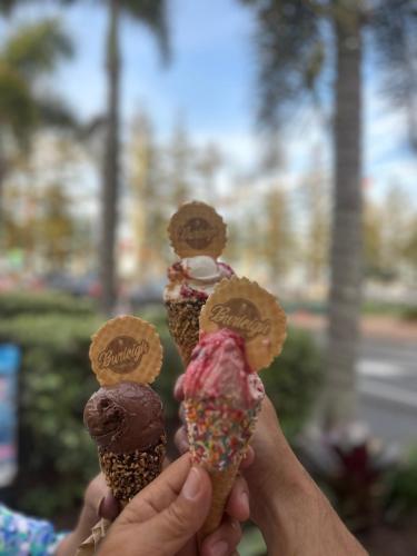 a person holding up three ice cream cones at 8th Floor Sunny Escape at Landmark Resort in Mooloolaba