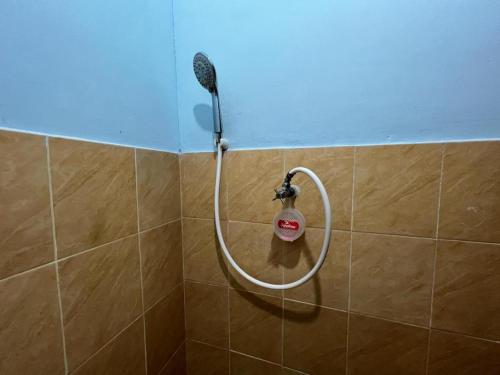 y baño con ducha y cabezal de ducha. en OYO 93629 Villa Cemara Syariah, en Mojokerto
