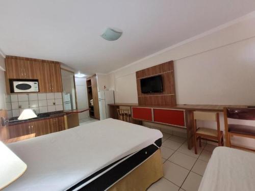 Una habitación con una cama y una cocina con una mesa. en diRoma Exclusive RM Hospedagem, en Caldas Novas