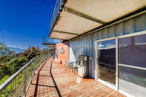 an outdoor deck with chairs and tables on a building at Water Swing B&B in Renai