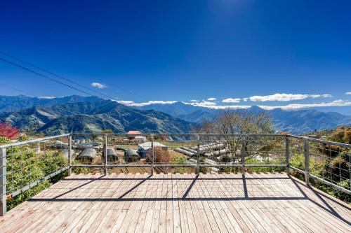 a wooden deck with a view of mountains at Water Swing B&B in Renai