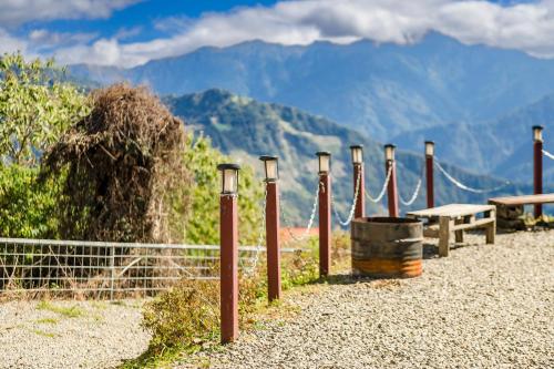 a bench and a fence with mountains in the background at Water Swing B&B in Renai