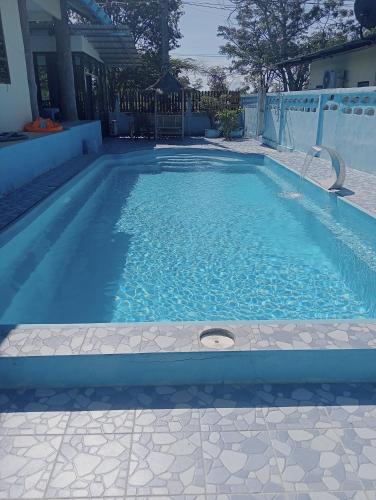 a swimming pool with blue water in a house at River restaurant&room service ครัวริมน้ำ อาหารตามสั่ง&ห้องพักรายวัน in Ban Ranuk