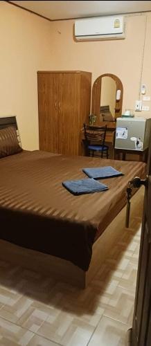 um quarto com uma cama grande e toalhas azuis em River restaurant&room service ครัวริมน้ำ อาหารตามสั่ง&ห้องพักรายวัน em Ban Ranuk