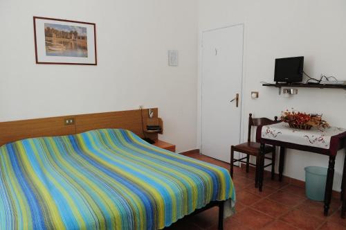 1 dormitorio con cama, mesa y escritorio en Albergo Belvedere, en Acqui Terme