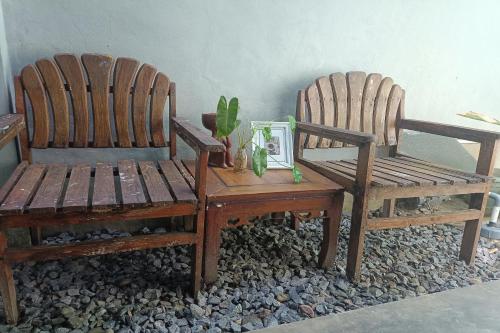 duas cadeiras de madeira e uma mesa com uma planta em OYO 93638 Lotus Guest House em Lombok