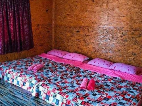 a room with two beds with pink pillows on them at Ameen Homestay อามีน โฮมสเตย์ in Ban Komo Sam Sip Paet