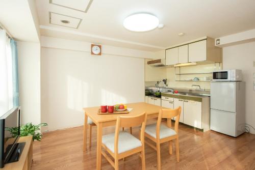 a small kitchen with a wooden table and chairs at 札幌市中心部大通公園まで徒歩十分観光移動に便利なロケーションh602#11B in Sapporo