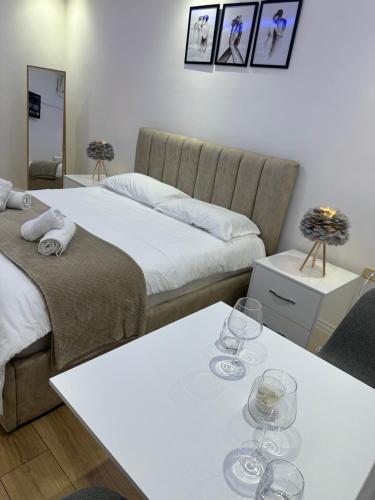 um quarto com duas camas e duas mesas com copos de vinho em Apartment in the heart of Tirana em Tirana