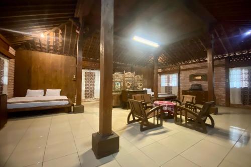 Habitación con mesa, sillas y cama en OYO Homes 93598 Omah Baturan Syariah, en Solo